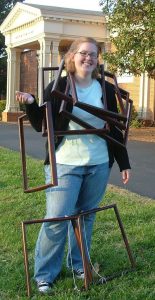 A member of the student club, FRAME, holding several frames in front of the Museum